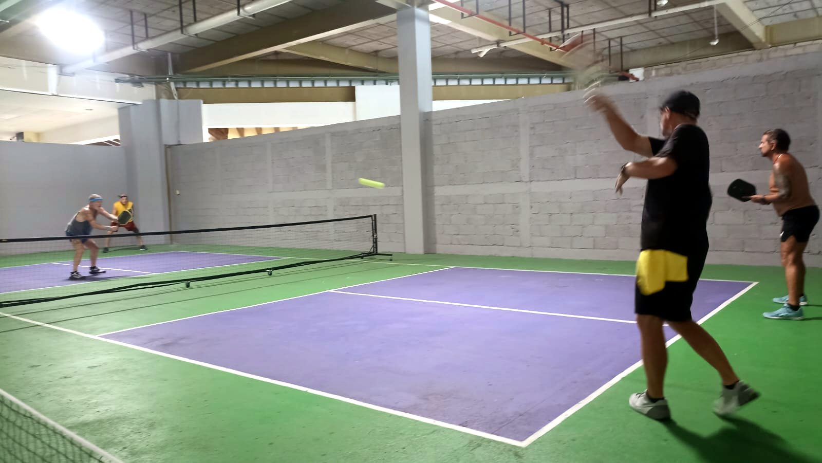 Evening open play under the lights on the indoor courts at Puerto Mágico